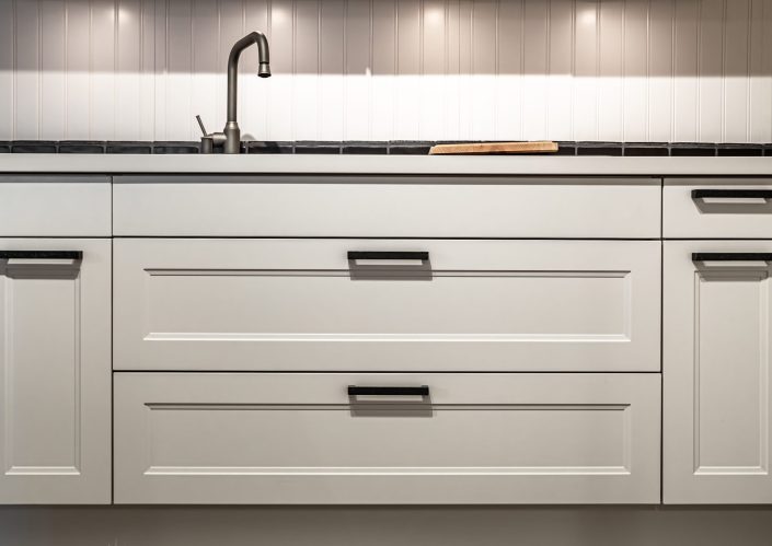 White kitchen cabinets with metal pulls or knobs in home interior.